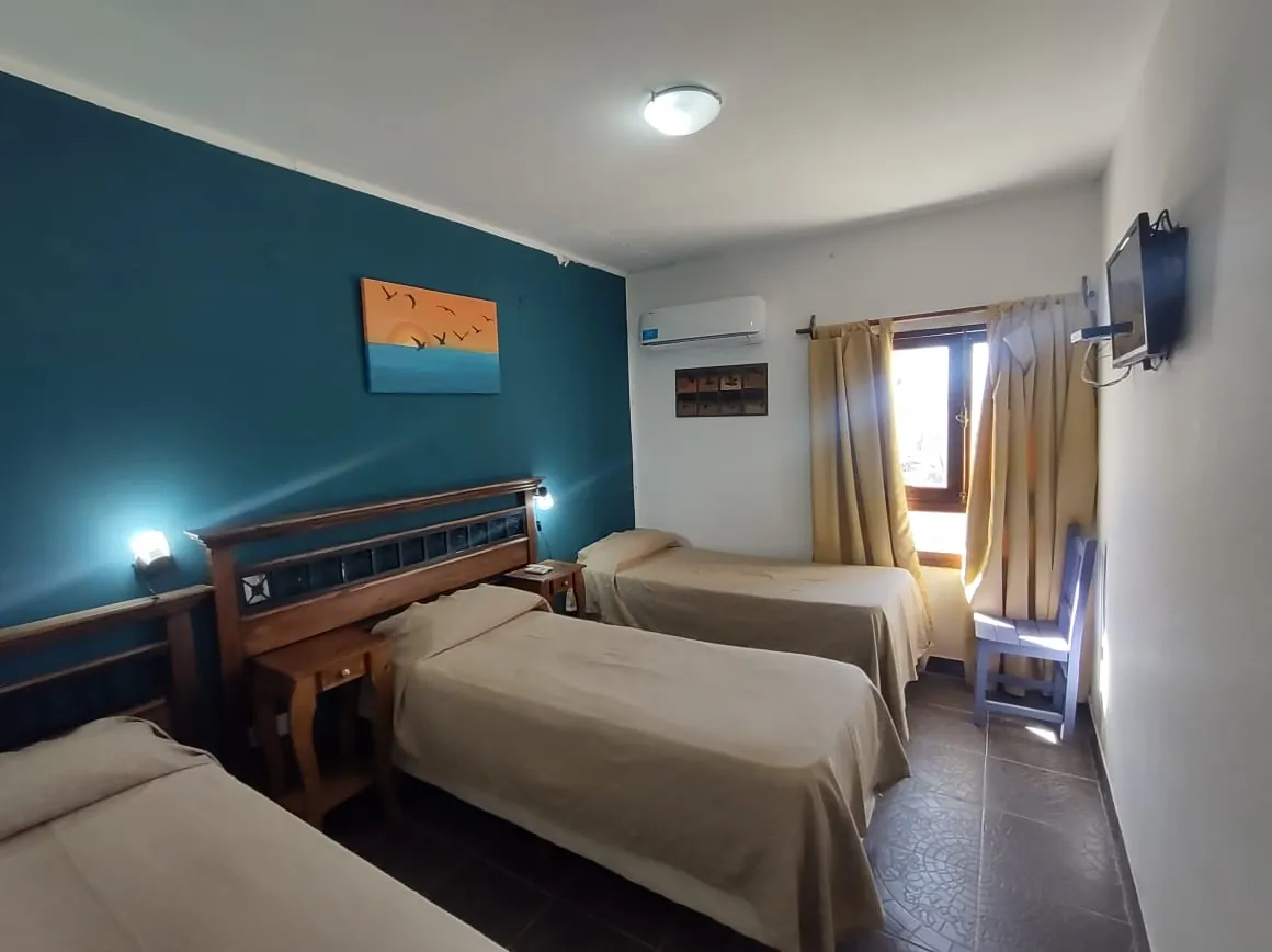 Habitación triple con pared turquesa